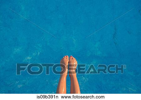 Young girl floating in swimming pool, focus on feet View Large Photo Image Picture - Young girl floating in swimming pool, focus on feet. Fotosearch