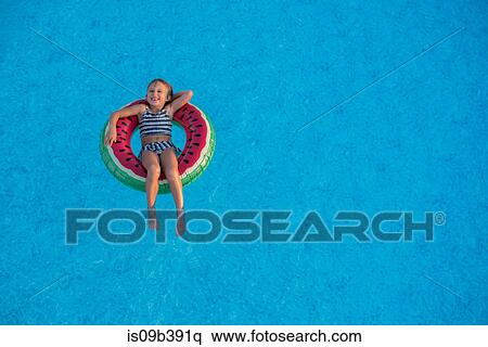 Young girl in swimming pool, relaxing on inflatable ring View Large Photo Image Stock Photography - Young girl in swimming pool, relaxing on inflatable ring. Fotosearch