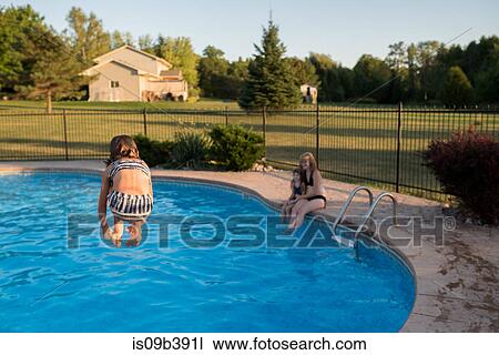 Young girl jumping into swimming pool, rear view View Large Photo Image Stock Image - Young girl jumping into swimming pool, rear view. Fotosearch