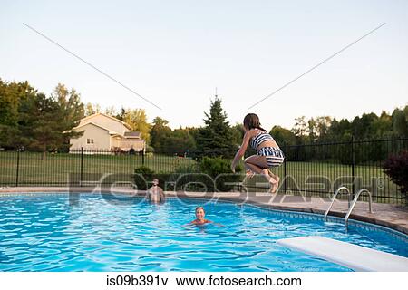 Stock Photo - Young girl jumping into swimming pool, father and grandmother watching. Fotosearch