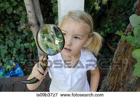 Stock Photo - Young girl looking through magnifying glass. Fotosearch