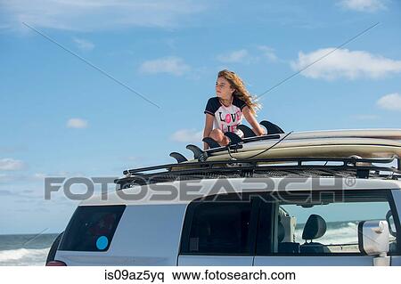 Young girl on top of car, looking at view View Large Photo Image Stock Photography - Young girl on top of car, looking at view. Fotosearch