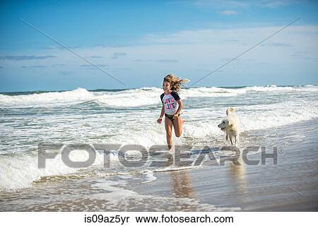 Young girl running through sea with dog View Large Photo Image Stock Photography - Young girl running through sea with dog. Fotosearch