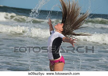 Young girl standing in sea, flicking wet hair View Large Photo Image Stock Photograph - Young girl standing in sea, flicking wet hair. Fotosearch