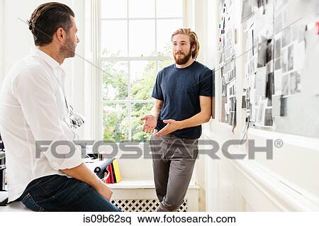 Young male designer explaining mood board idea to colleague in creative studio View Large Photo Image Stock Photography - Young male designer explaining mood board idea to colleague in creative studio. Fotosearch
