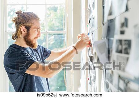 Young male designer pinning mood board ideas to wall in creative studio View Large Photo Image Stock Image - Young male designer pinning mood board ideas to wall in creative studio. Fotosearch