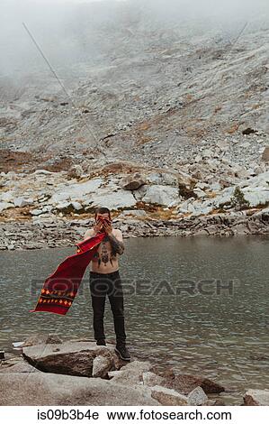 Stock Image - Young male hiker drying face with towel at lake, Mineral King, Sequoia National Park, California, USA. Fotosearch