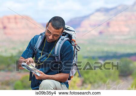 Young male hiker looking at map, Sedona, Arizona, USA View Large Photo Image Picture - Young male hiker looking at map, Sedona, Arizona, USA. Fotosearch