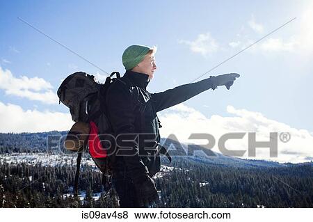 Stock Photo - Young male hiker pointing out to mountain forests, Ashland, Oregon, USA. Fotosearch