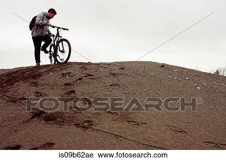 Young male mountain biker preparing to bike from quarry hill View Large Photo Image Stock Image - Young male mountain biker preparing to bike from quarry hill. Fotosearch