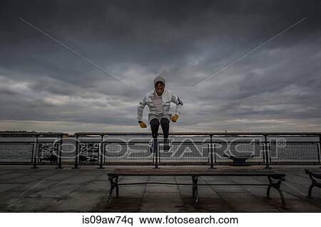 Young man bench jump training on riverside at dawn View Large Photo Image Stock Photography - Young man bench jump training on riverside at dawn. Fotosearch