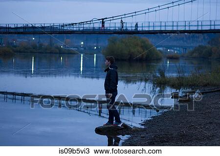 Stock Image - Young man by pedestrian bridge, Chusovoy, Russia. Fotosearch
