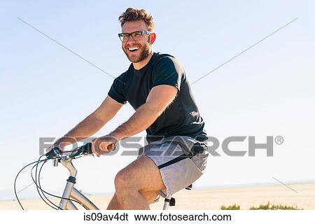 Young man, cycling, smiling View Large Photo Image Stock Photograph - Young man, cycling, smiling. Fotosearch