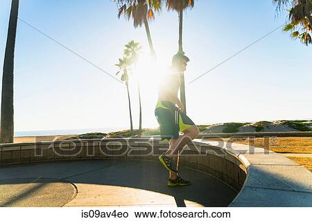 Young man exercising, stretching, outdoors View Large Photo Image Picture - Young man exercising, stretching, outdoors. Fotosearch