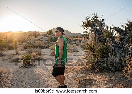 Stock Image - Young man in Joshua Tree National Park at sunset, California, USA. Fotosearch