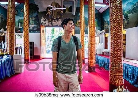Stock Photography - Young man inside Wat Thung Yu Temple, Chiang Mai, Thailand. Fotosearch