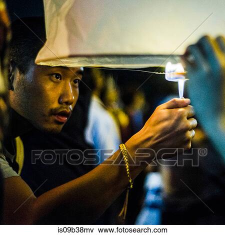 Young man lighting paper lantern for Loy Krathong Paper Lantern Festival in Chiang Mai, Thailand View Large Photo Image Stock Photo - Young man lighting paper lantern for Loy Krathong Paper Lantern Festival in Chiang Mai, Thailand. Fotosearch