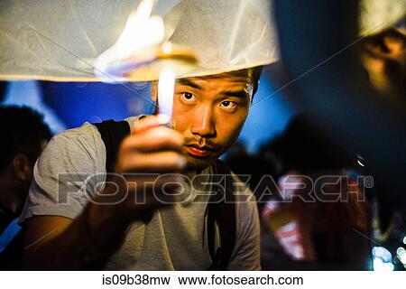 Young man lighting paper lantern for Loy Krathong Paper Lantern Festival in Chiang Mai, Thailand View Large Photo Image Stock Photo - Young man lighting paper lantern for Loy Krathong Paper Lantern Festival in Chiang Mai, Thailand. Fotosearch