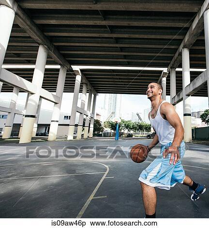 Young man on basketball court holding basketball looking up smiling View Large Photo Image Stock Photography - Young man on basketball court holding basketball looking up smiling. Fotosearch