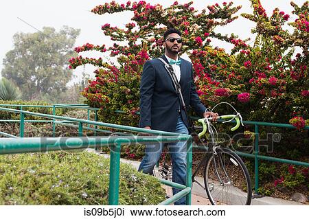 Young man pushing bicycle onto rail station platform View Large Photo Image Stock Image - Young man pushing bicycle onto rail station platform. Fotosearch