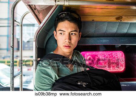 Stock Photography - Young man sitting in back of tuk tuk, Chiang Mai, Thailand. Fotosearch