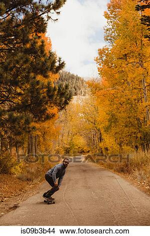 Young man skateboarding on rural road in autumn forest, Mineral King, Sequoia National Park, California, USA View Large Photo Image Picture - Young man skateboarding on rural road in autumn forest, Mineral King, Sequoia National Park, California, USA. Fotosearch
