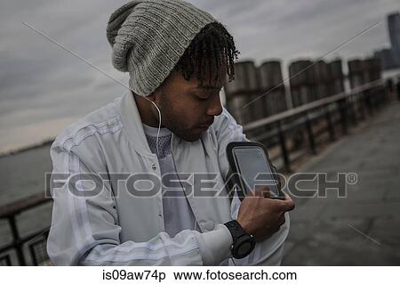 Young man training on riverside at dawn using smartphone touchscreen View Large Photo Image Stock Photography - Young man training on riverside at dawn using smartphone touchscreen. Fotosearch