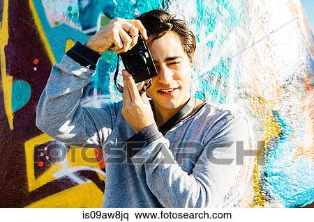 Young man using digital camera View Large Photo Image Stock Photography - Young man using digital camera. Fotosearch