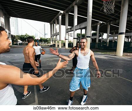 Young men on basketball court connecting with handshake after basketball game smiling View Large Photo Image Picture - Young men on basketball court connecting with handshake after basketball game smiling. Fotosearch