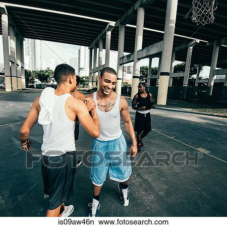 Young men on basketball court connecting with handshake after basketball game smiling View Large Photo Image Picture - Young men on basketball court connecting with handshake after basketball game smiling. Fotosearch