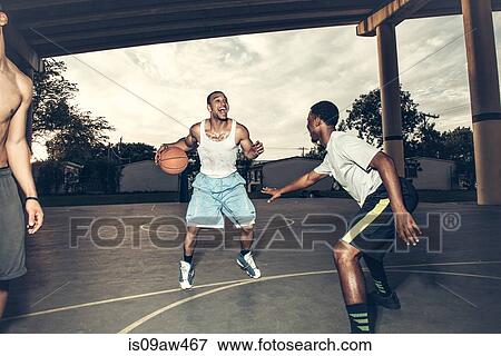 Young men playing basket ball on basket ball court smiling View Large Photo Image Stock Photo - Young men playing basket ball on basket ball court smiling. Fotosearch