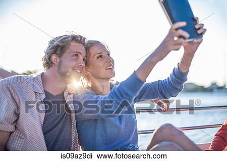 Young tourist couple taking digital tablet selfie on boat trip, Cape Town, South Africa View Large Photo Image Stock Image - Young tourist couple taking digital tablet selfie on boat trip, Cape Town, South Africa. Fotosearch