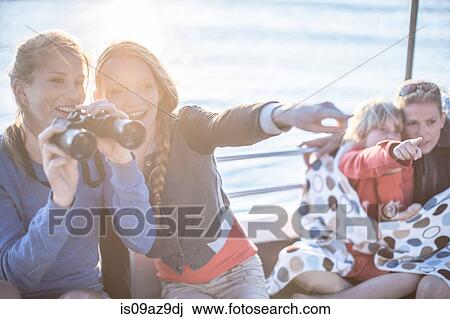 Stock Image - Young tourist woman and girl with binoculars on boat trip, Cape Town, South Africa. Fotosearch