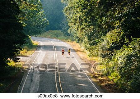 Young woman and teenage girl running along rural road View Large Photo Image Stock Photo - Young woman and teenage girl running along rural road. Fotosearch