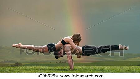 Young woman balancing on top of man in prone position, practicing yoga in front of rainbow View Large Photo Image Stock Photograph - Young woman balancing on top of man in prone position, practicing yoga in front of rainbow. Fotosearch