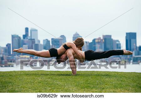 Young woman balancing on top of man in prone position, practicing yoga in front of Seattle skyline View Large Photo Image Stock Photography - Young woman balancing on top of man in prone position, practicing yoga in front of Seattle skyline. Fotosearch