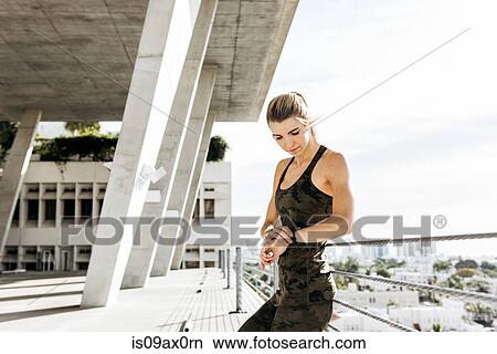Young woman checking activity tracker after exercise View Large Photo Image Picture - Young woman checking activity tracker after exercise. Fotosearch