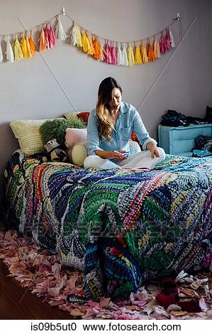 Young woman cross legged on shabby chic bed writing in notebook View Large Photo Image Stock Image - Young woman cross legged on shabby chic bed writing in notebook. Fotosearch