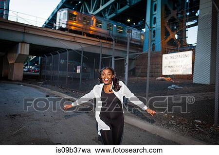 Young woman dancing in street, smiling View Large Photo Image Stock Image - Young woman dancing in street, smiling. Fotosearch