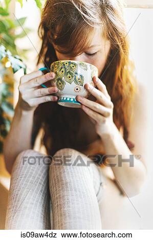 Young woman drinking from teacup View Large Photo Image Stock Photo - Young woman drinking from teacup. Fotosearch