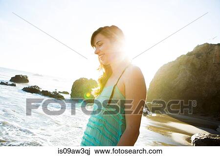 Stock Image - Young woman enjoying beach. Fotosearch