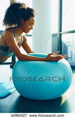 Young woman exercising in gym, using inflatable exercise ball View Large Photo Image Stock Photo - Young woman exercising in gym, using inflatable exercise ball. Fotosearch