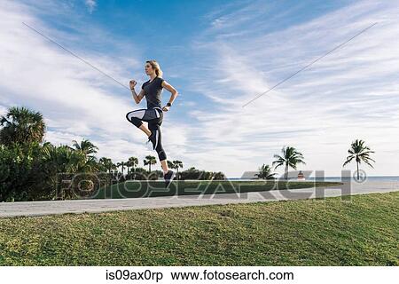 Young woman exercising outdoors, jumping View Large Photo Image Stock Photography - Young woman exercising outdoors, jumping. Fotosearch