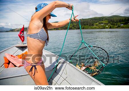 Young woman hauling in crab trap on fishing boat, Nehalem Bay, Oregon, USA View Large Photo Image Picture - Young woman hauling in crab trap on fishing boat, Nehalem Bay, Oregon, USA. Fotosearch