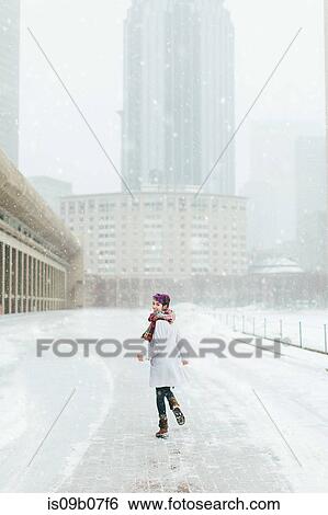 Stock Photograph - Young woman in front of the Christian Science Centre and Prudential building with snow, Boston, Massachusetts, USA. Fotosearch