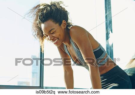 Stock Photography - Young woman in gym, laughing. Fotosearch