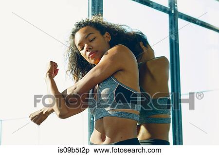 Stock Photography - Young woman in gym, stretching. Fotosearch
