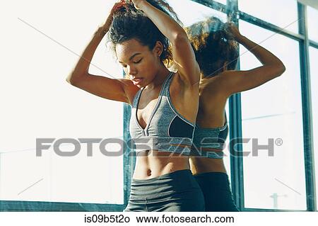 Picture - Young woman in gym, taking a break from workout. Fotosearch