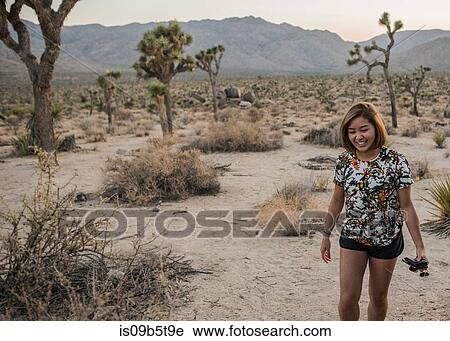 Stock Image - Young woman in Joshua Tree National Park at dusk, California, USA. Fotosearch