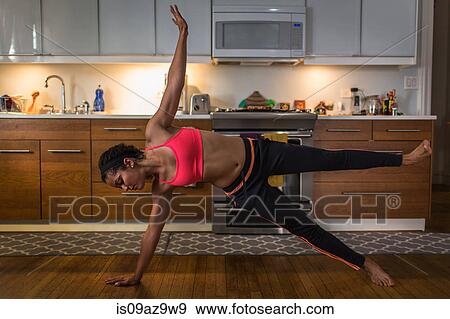 Young woman in kitchen, in yoga position View Large Photo Image Stock Photo - Young woman in kitchen, in yoga position. Fotosearch